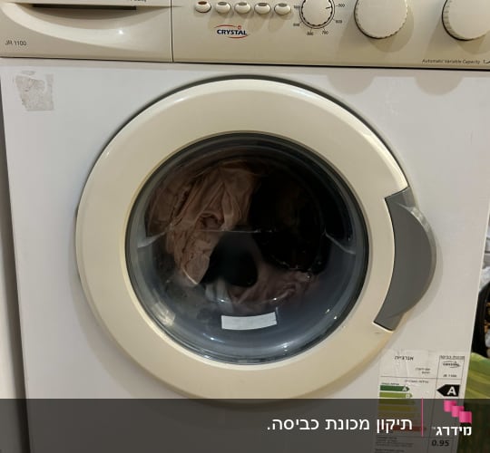 מכונת כביסה עם בגדים בתוף ותווית אנרגיה